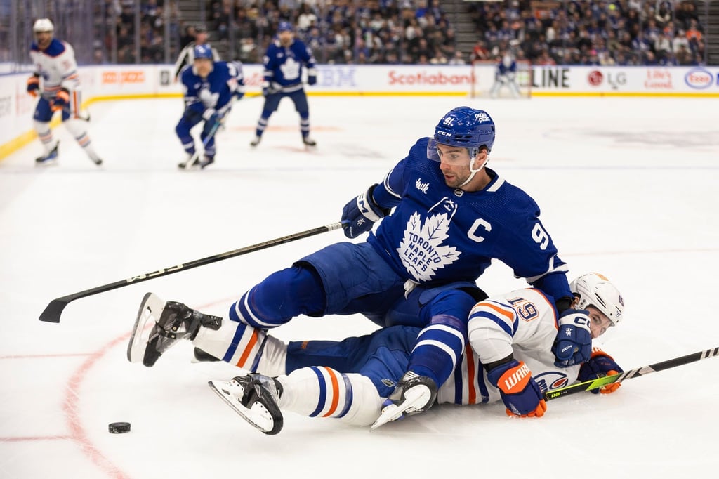 Adam Henrique von den Edmonton Oilers verliert den Zweikampf um den Puck mit John Tavares (oben) von den Toronto Maple Leafs.