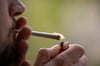 Ein junger Mann raucht einen Joint