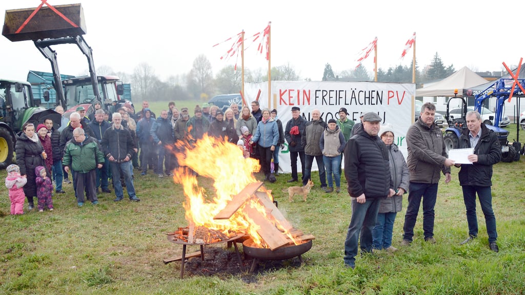 Die Gemeinderatsmitglieder Gerald Kathke (rechts), Renate Moesenthin und Torsten Krüger (4. von rechts) übergaben die von der BI gegen Freiflächen-Photovoltaik bei Kossebau gesammelten Unterschriften am Rande eines Mahnfeuers an den Bürgermeister der „Altmärkischen Höhe“, Bernd Prange.