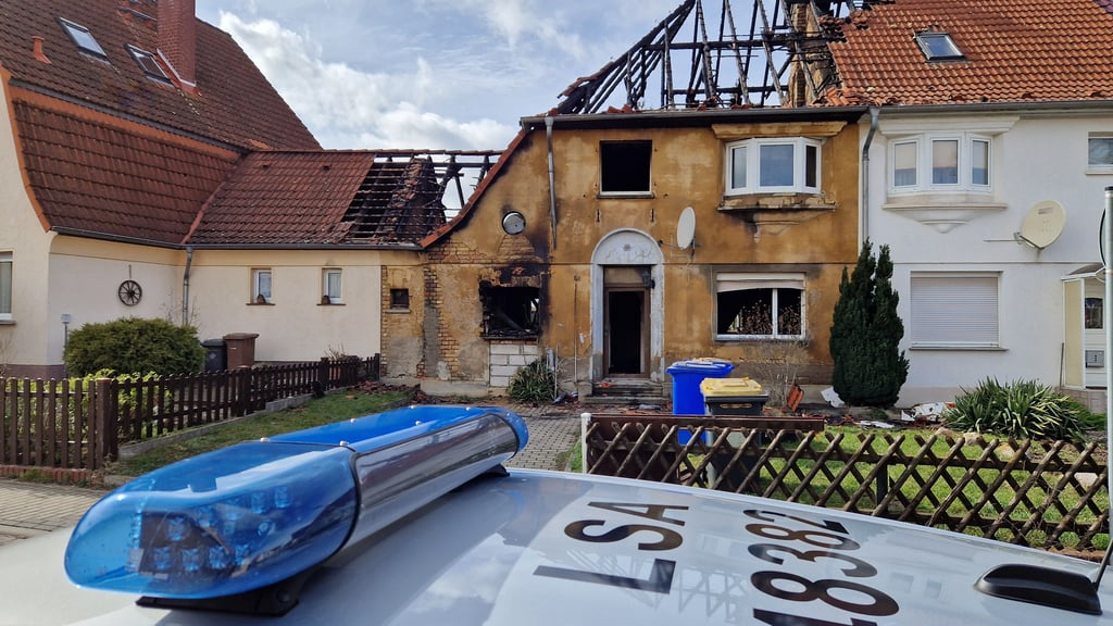 Am Tag nach dem Brand eines Hauses in Mücheln bewacht die Polizei den Tatort. Das Gebäude ist gesperrt, bis die Kripo nach Spuren einer möglichen Brandstiftung gesucht hat.