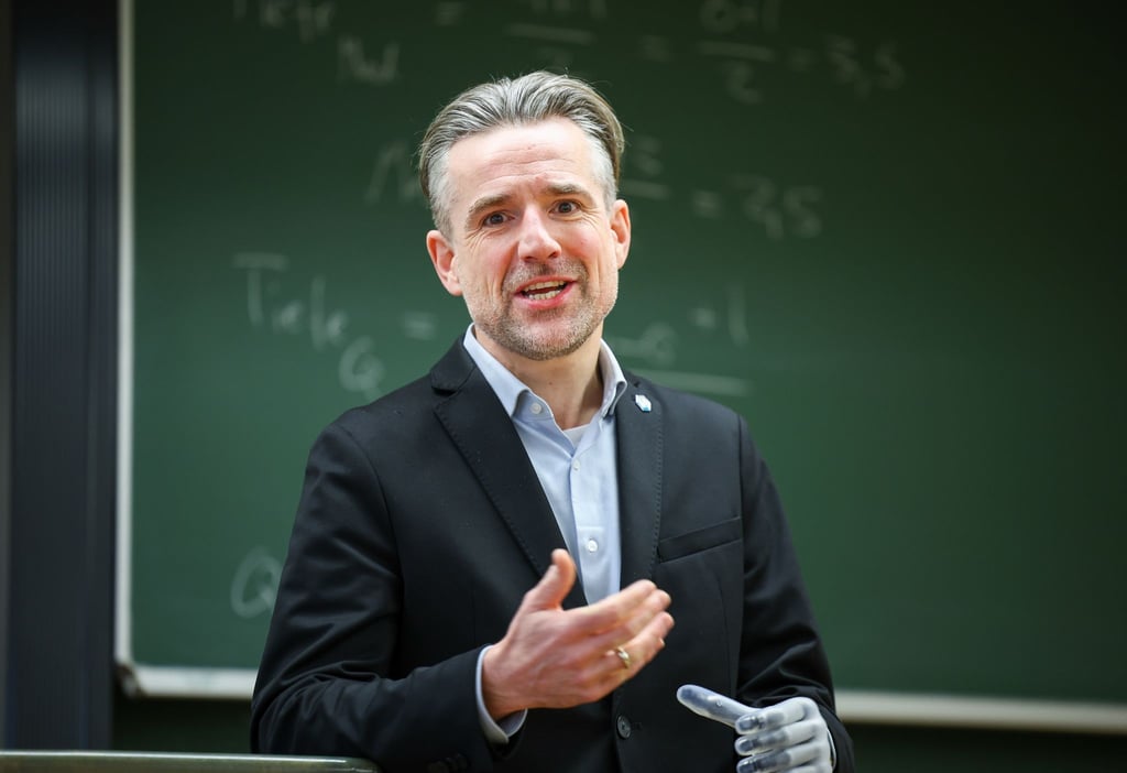Bertolt Meyer sitzt in einem Hörsaal im Institut für Psychologie.