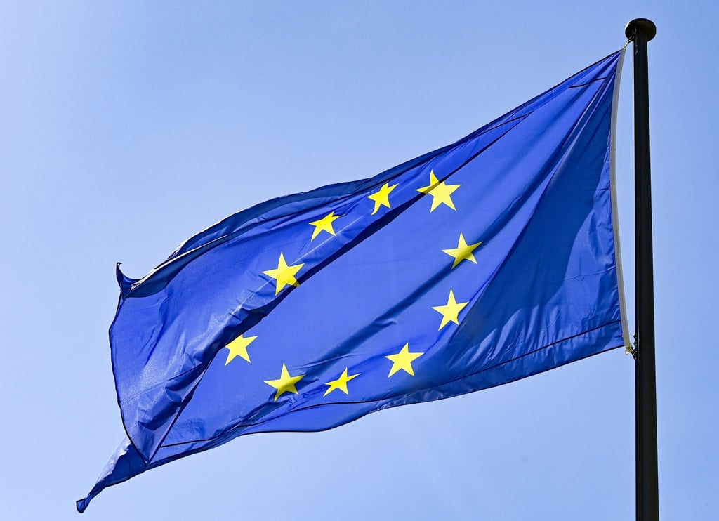 Eine Europaflagge weht vor blauem Himmel.