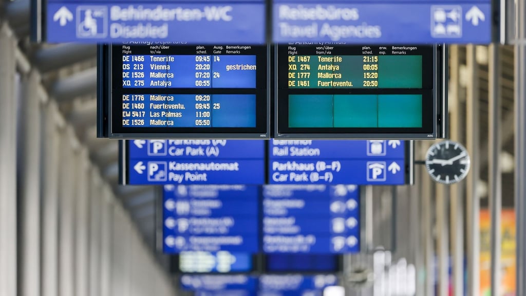 Schilder und Anzeigentafeln zeigen verschiedene Flüge an.