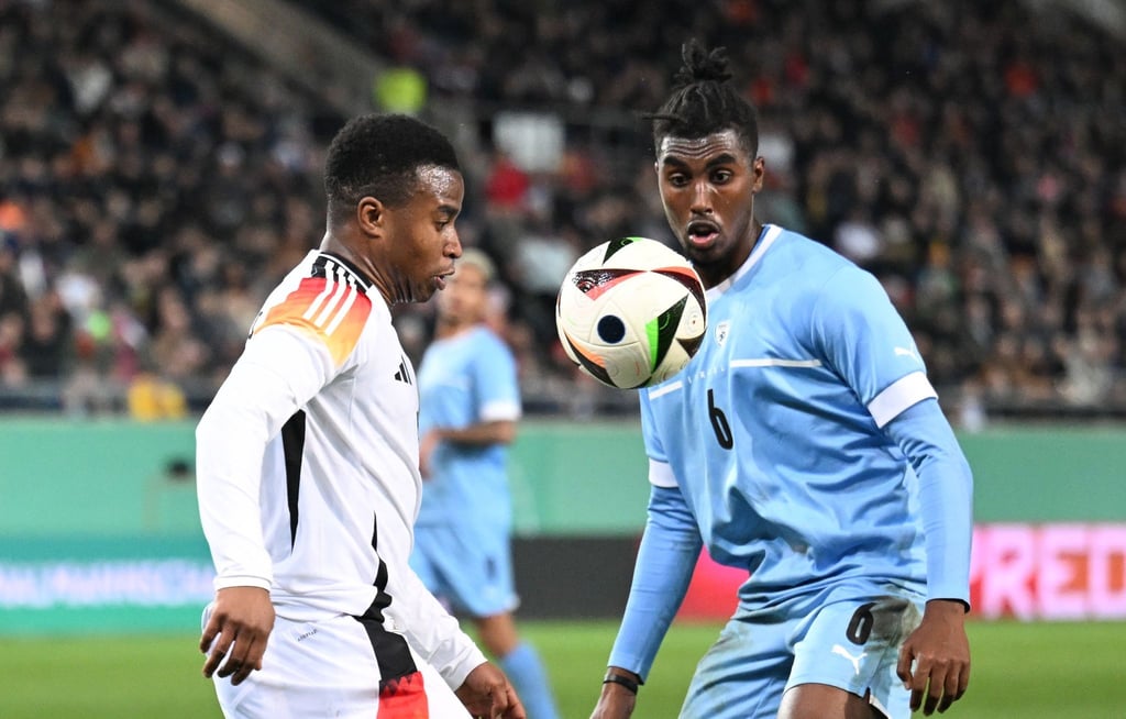 Deutschlands Youssoufa Moukoko (l) und Israels Ayanaw Ferede kämpfen um den Ball.