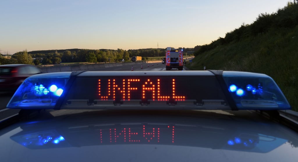 Ein Polizeifahrzeug warnt mit einer Leuchtschrift vor einer Unfallstelle.