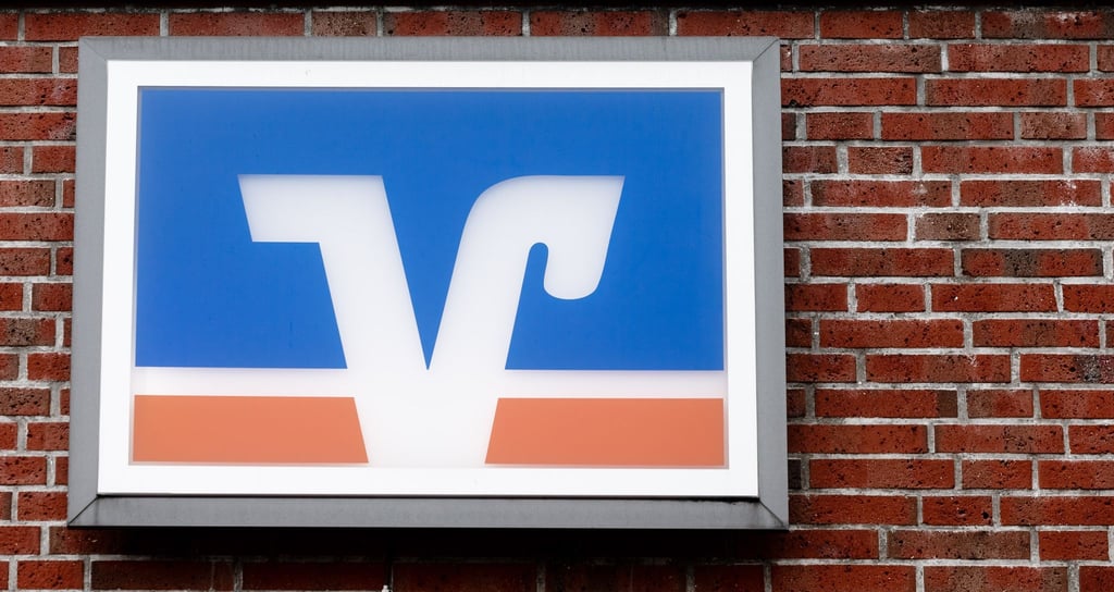 Das Logo der Volks- und Raiffeisenbanken hängt über einer Geschäftsstelle.