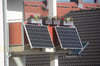 Solarmodule für ein sogenanntes Balkonkraftwerk hängen an einem Balkon  (Symbolbild).