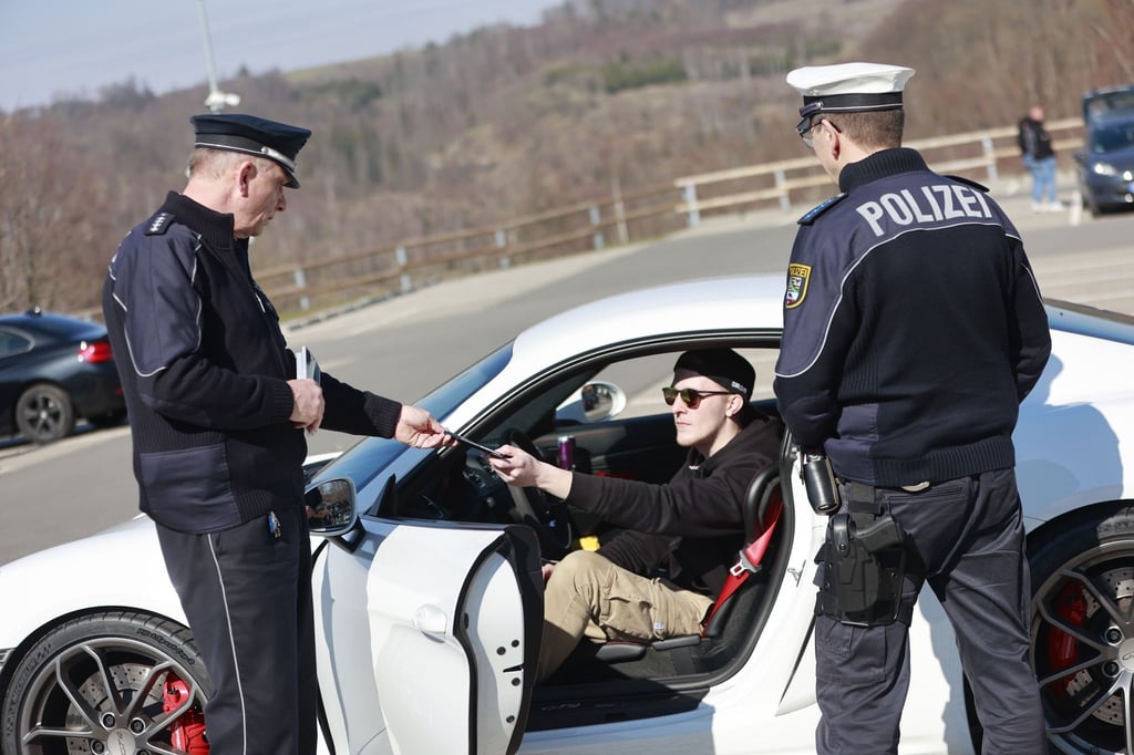 Einsatzkräfte der Polizei kontrollieren auf dem Parkplatz der Rappbodetalsperre einen Verkehrsteilnehmer.