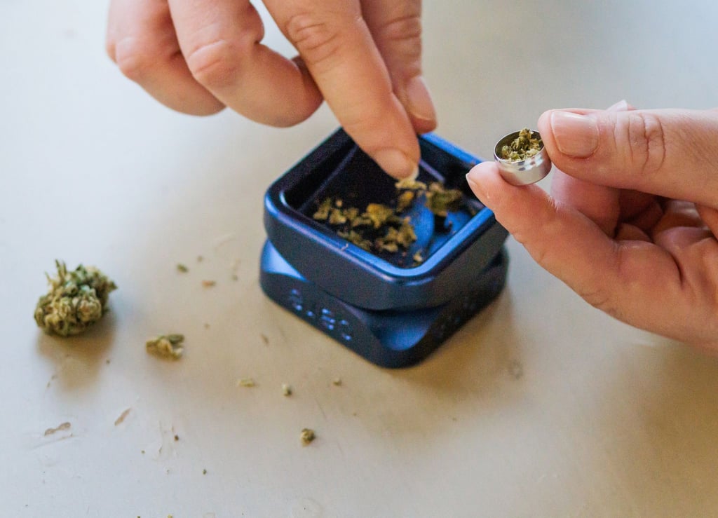 Eine Patientin füllt zerkleinertes medizinisches Cannabis in eine Metallkapsel.