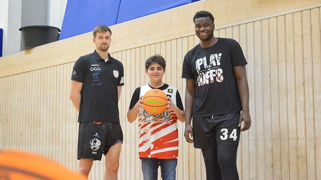 Nach seinem Angriff durch einen Pitbull erhält Basketball-Fan Arman (Mitte) moralische Unterstützung von den SBB Baskets Wolmirtsedt. Bis auf ein Heimspiel seiner Idole Leon Hoppe (l.) und Fabien Kondo hat er kein Spiel verpasst.