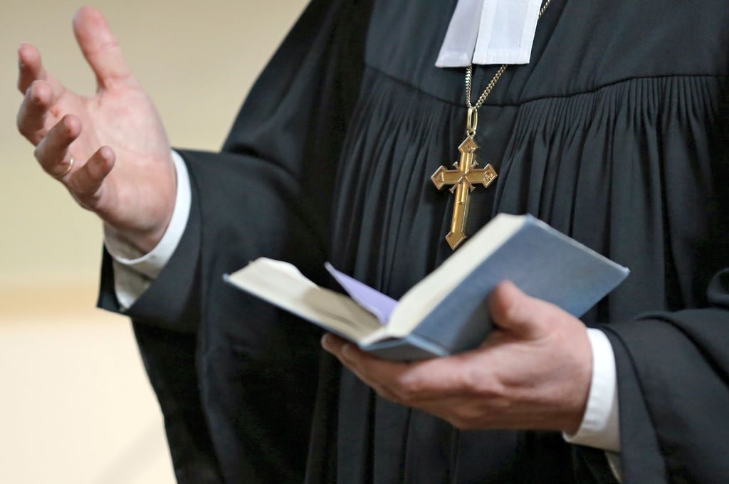 Ein Geistlicher der Evangelischen Landeskirche Sachsen-Anhalts hält ein Gesangbuch in der Hand.