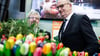 Dietmar Woidke (r,SPD), Ministerpräsident von Brandenburg, und Axel Vogel (Bündnis 90/Die Grünen), Landwirtschaftsminister, stehen hinter Kunstblumen.