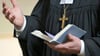 Ein Geistlicher der Evangelischen Landeskirche Sachsen-Anhalts hält ein Gesangbuch in der Hand.