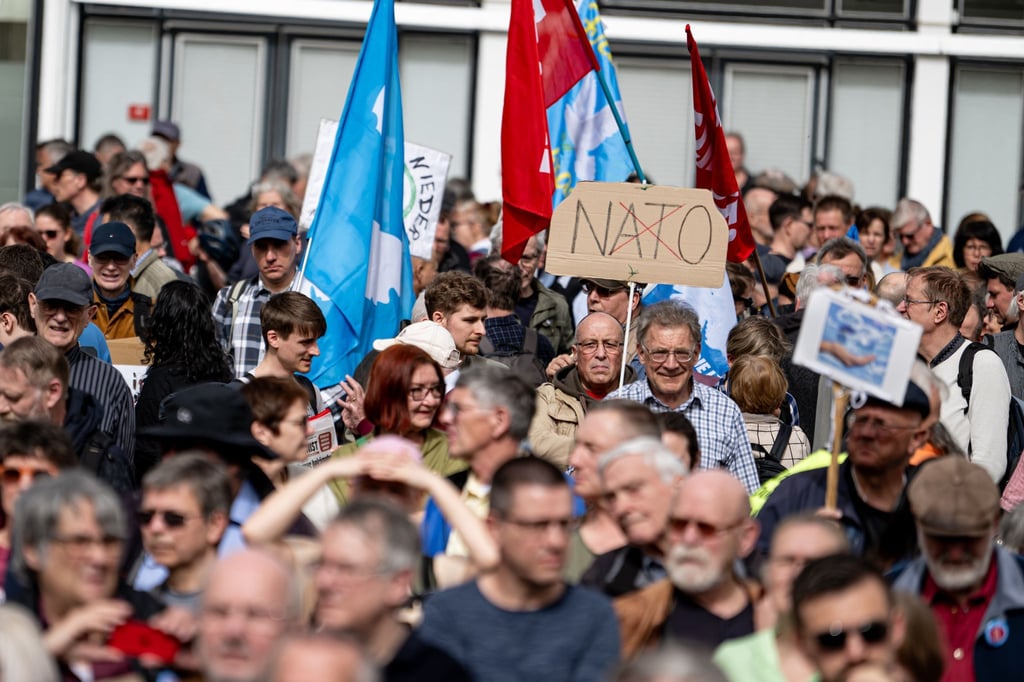 Ein Pappschild mit dem durchgestrichenen Wort "Nato" ist auf dem traditionellen Ostermarsch unter dem Motto „Kriegstüchtig - Nie wieder“ zu sehen.