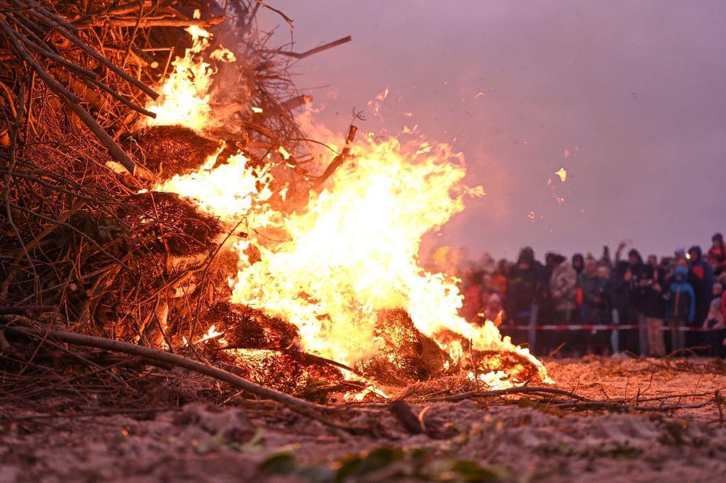 Ein Osterfeuer am Strand lockt zahlreiche Zuschauer an.