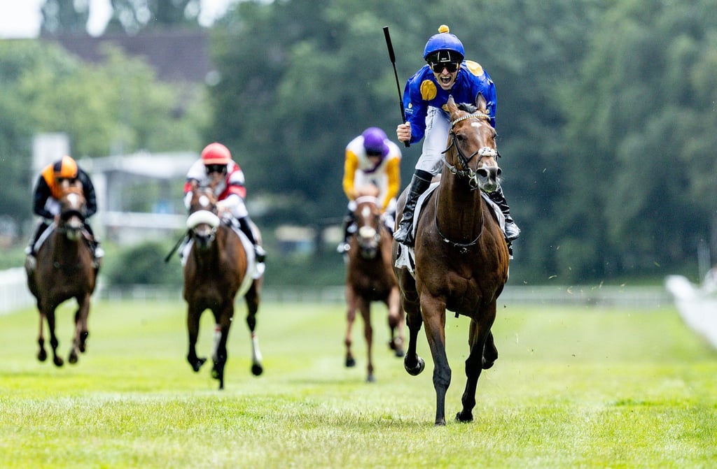„Fantastic Moon“ mit Jockey Rene Piechulek reitet über die Ziellinie und gewinnt das Deutsche Derby.