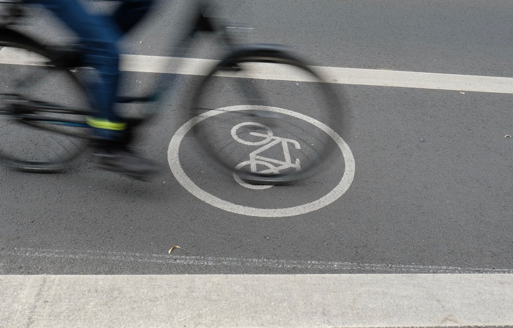 Ein Fahrradfahrer fährt auf dem Radfahrstreifen einer Fahrbahn.