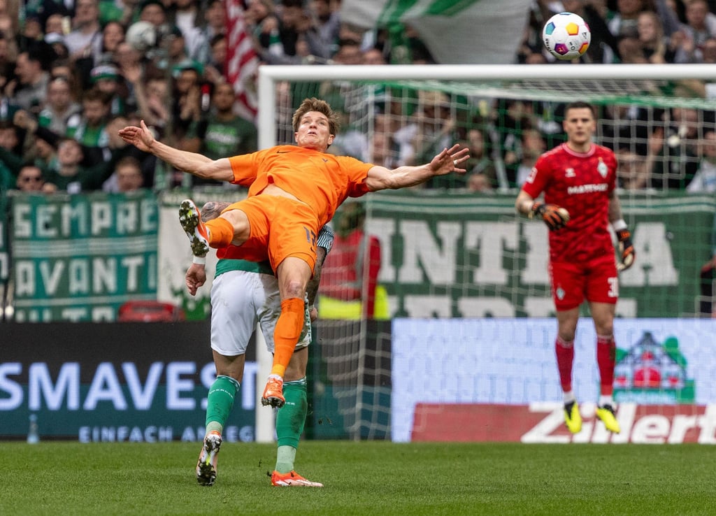 Wolfsburgs Kevin Behrens (vorne) und Bremens Marco Friedl kämpfen um den Ball.