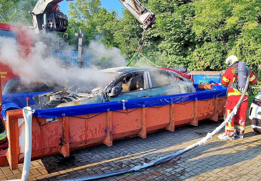 Ein E-Auto wird in einem Wasserbad gelöscht.