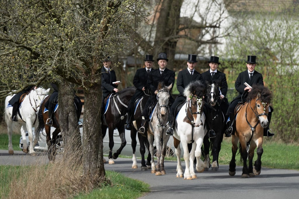 Die traditionell gekleideten sorbischen Osterreiter verkünden nach altem Brauch zu Pferde die Osterbotschaft.
