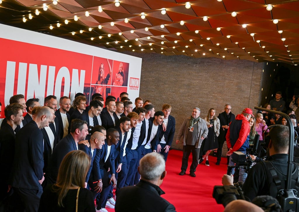 Der Cast und die Mannschaft von Union Berlin stehen bei der Filmpremiere auf dem roten Teppich im Kino International.
