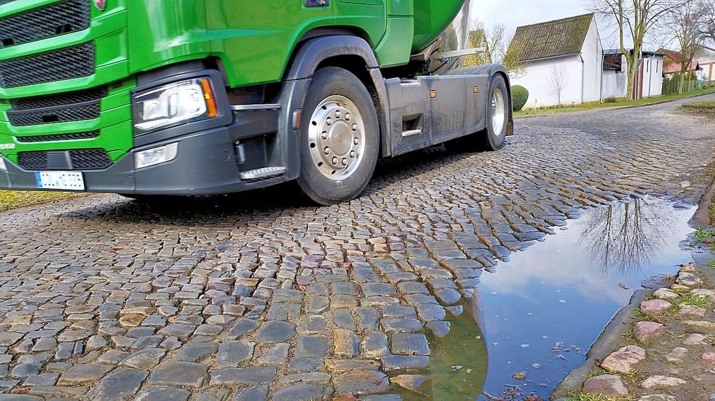 Ein  Lkw fährt über das ausgewaschene und deswegen nicht mehr feste Kopfsteinpflaster in Depekolk bei Salzwedel.