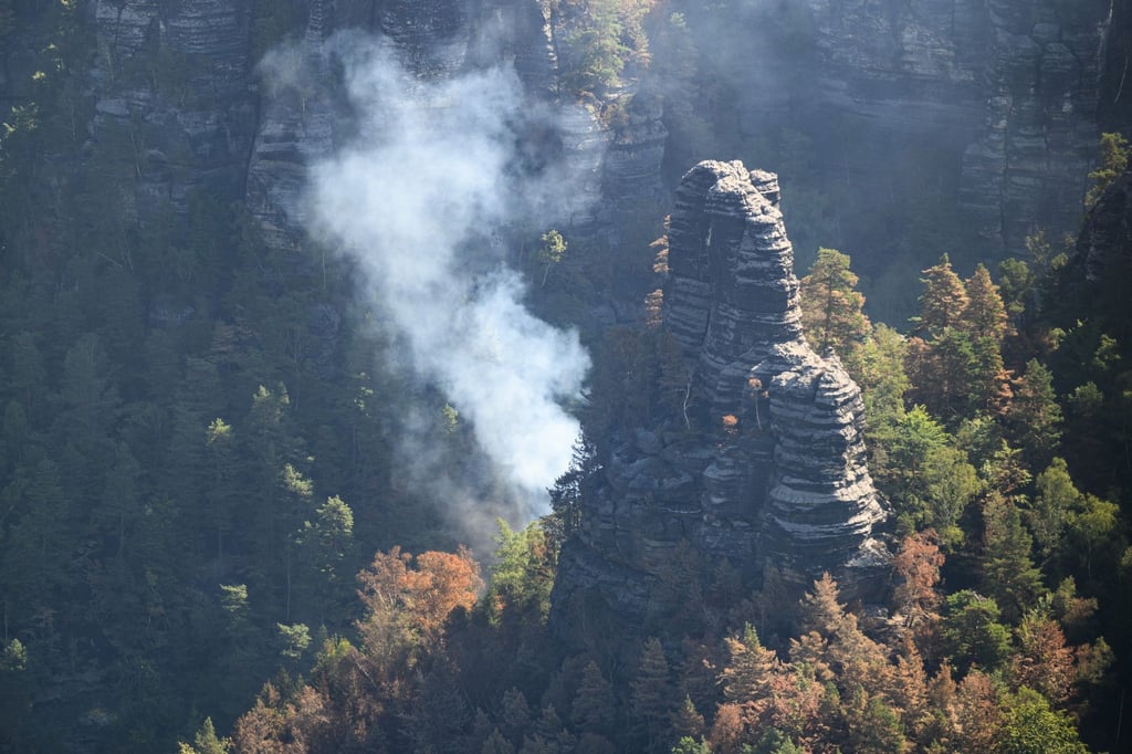 Rauch steigt bei einem Waldbrand im Nationalpark Sächsische Schweiz in den Himmel.