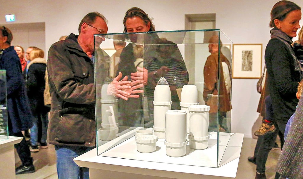 Bei der Eröffnung der Ausstellung „Das Ende der Mythen“ im November 2018 in Quedlinburg betrachten Besucher Keramiken von Friederike Nottrott: die „Geschossgranate zum Leben ‚Kaliber 10,5‘".