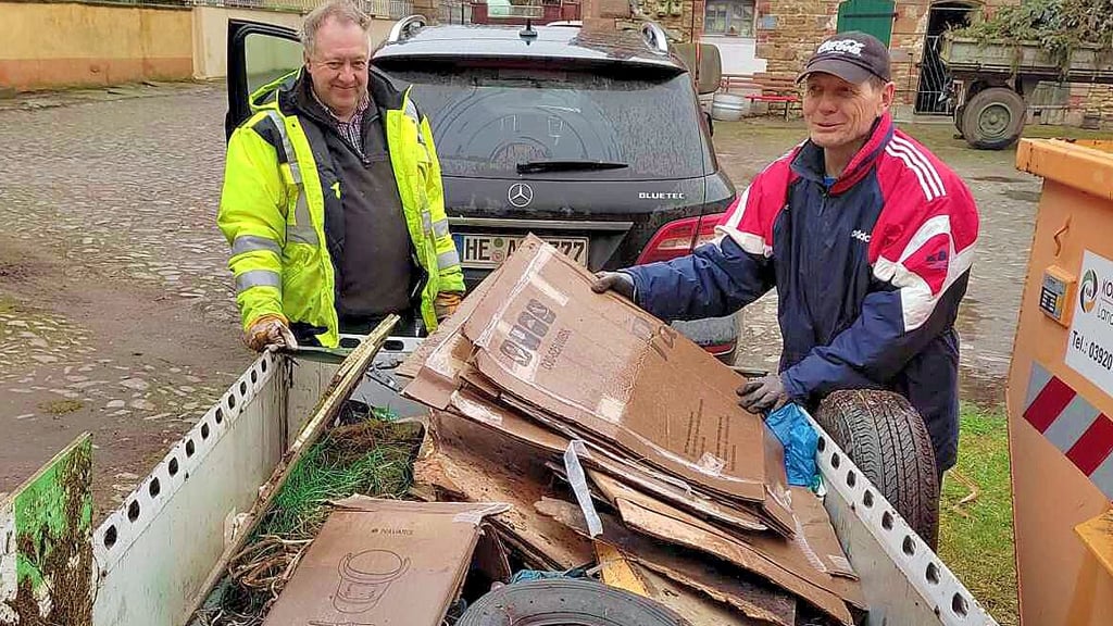 Daniel Scheibe (links) und Reiner Senf entladen aus einem Transporthänger den eingesammelten Müll.
