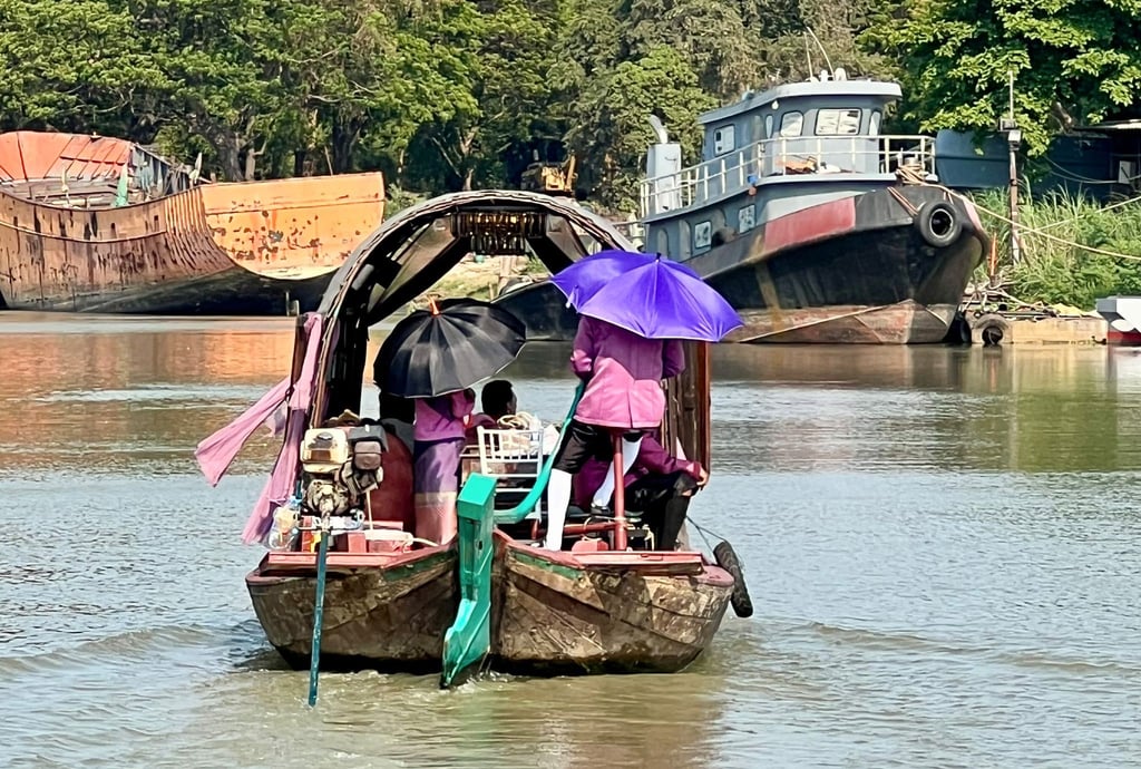Menschen auf dem Pa Sak River schützen sich mit Sonnenschirmen vor der Sonneneinstrahlung und der extremen Hitze in Thailand.