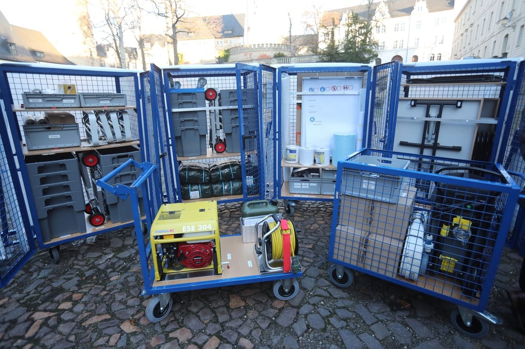 Ein Notstromgerät und andere Hilfsmittel stehen vor sogenannten Notfallcontainern Kulturgut.