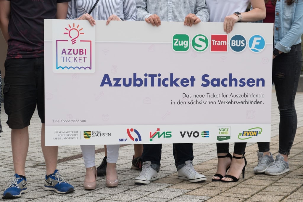 Auszubildende halten ein Transparent mit der Aufschrift „AzubiTicket Sachsen“.