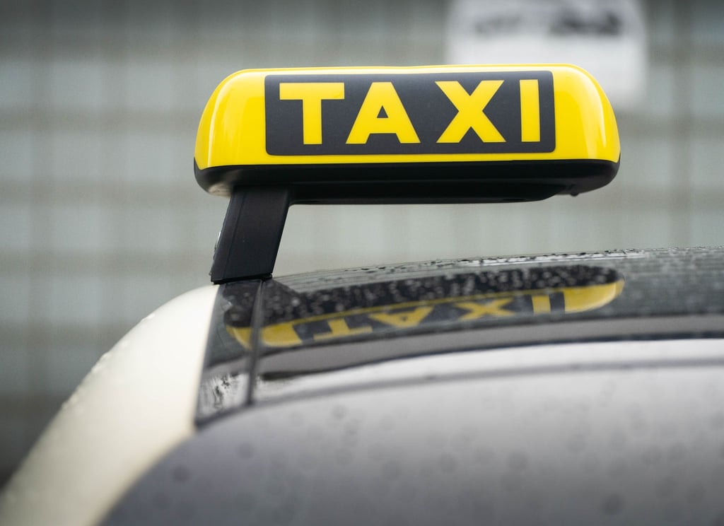 Ein Taxi-Schild ist auf dem Dach eines Fahrzeuges befestigt.