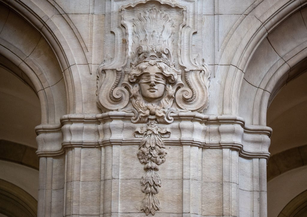 Ein Relief mit der Abbildung der Justitia an einer Säule in der Eingangshalle im Kriminalgericht Moabit.
