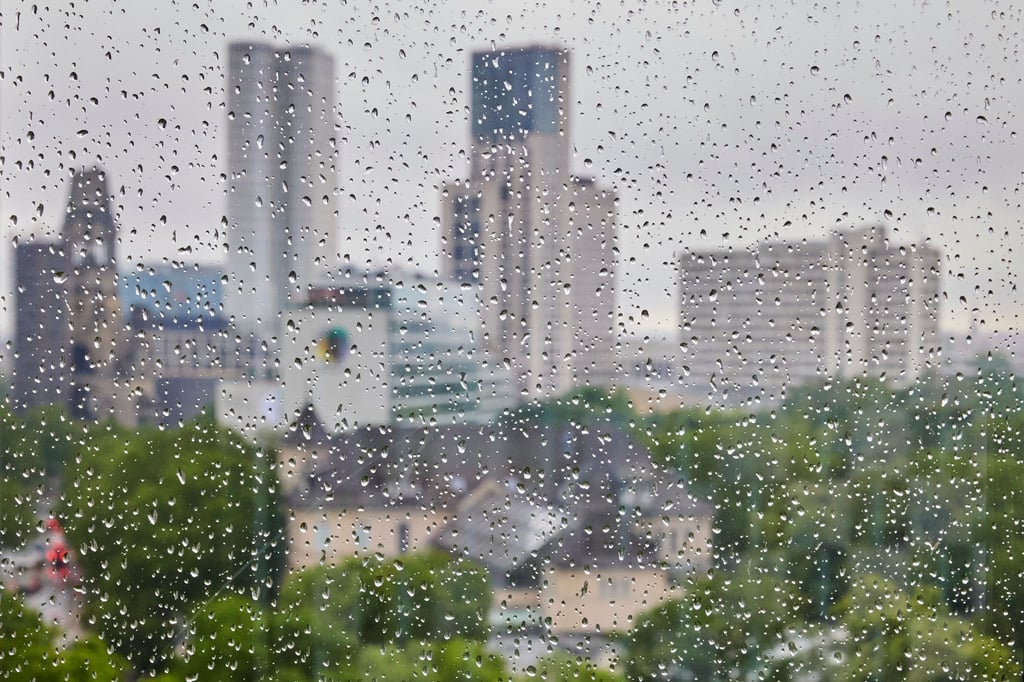 Regentropfen sind an einer Fensterscheibe vor der Skyline der City West zu sehen.