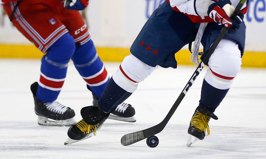 Zwei Eishockeyspieler kämpfen um den Puck.