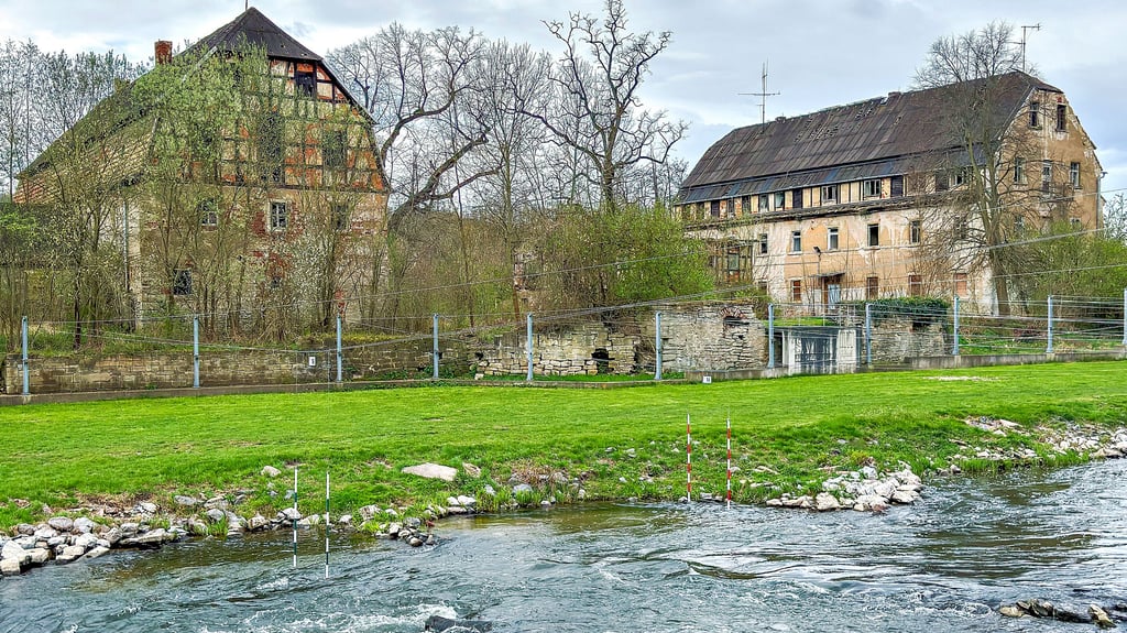 Blick über die Weiße Elster zu den Gebäuden, die von der Neumühle nahe des Banhofs Haynsburg noch ürbrig sind.
