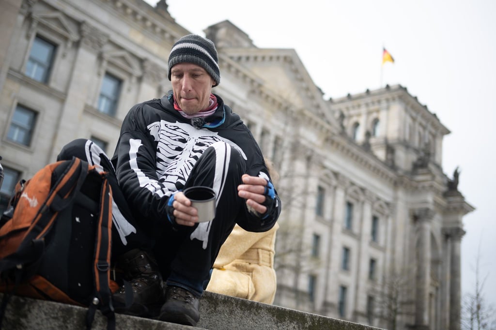 Klimaaktivist Wolfgang Metzeler-Kick macht mit Unterstützern im Hungerstreik-Camp des Bündnisses „Hungern bis ihr ehrlich seid“ bei einem Rundgang durch das Regierungsviertel eine Pause hinter dem Bundestag.