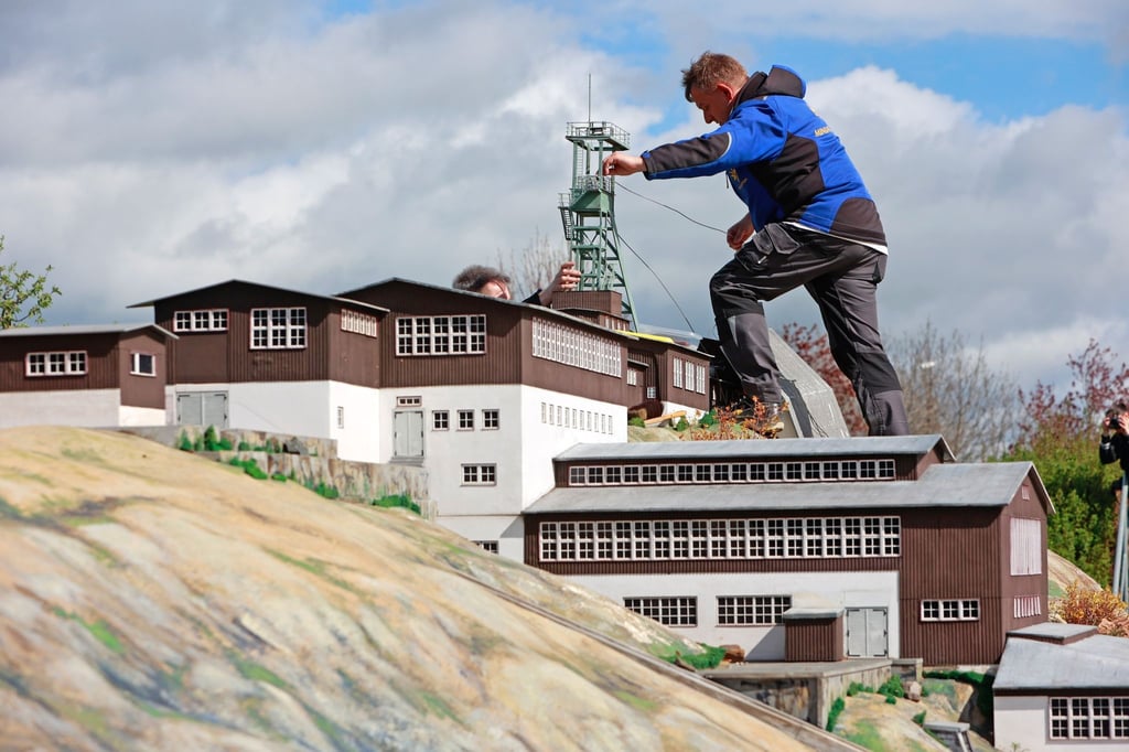 Mitarbeiter des Miniaturenparks Kleiner Harz stellen ein Modell des Besucherbergwerks Rammelsberg auf.