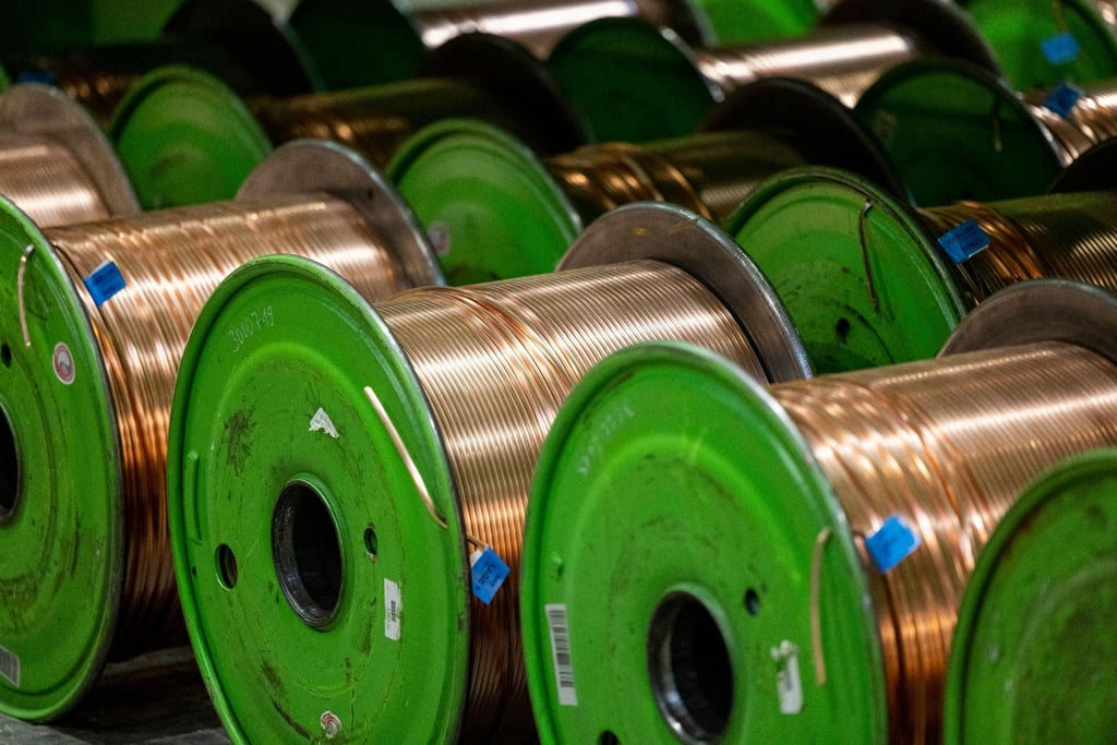 Kabeltrommeln mit aufgespultem Kupferkabel liegen in der Produktionshalle eines Unternehmens.
