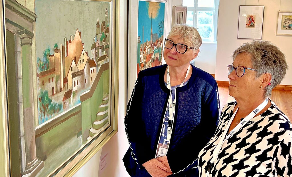Marga Becker (v.l.) und Christiane Heinrich schauen sich die Bernburg-Motive von Maler Heinz Steffens bei der Ausstellungseröffnung im Museum Schloss Bernburg an.
