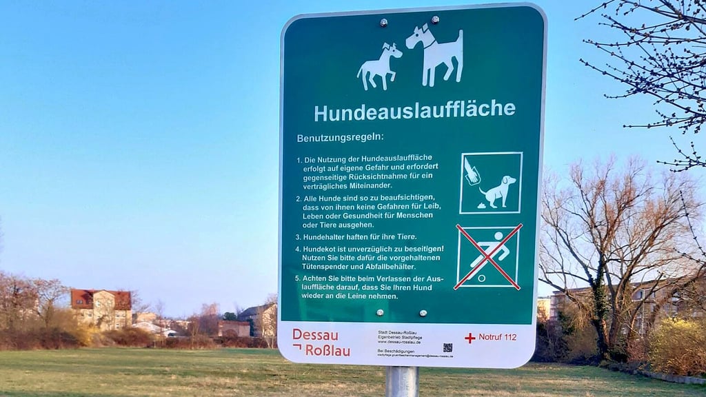 Schilder weisen auf die Regeln auf der Hundewiese hin.