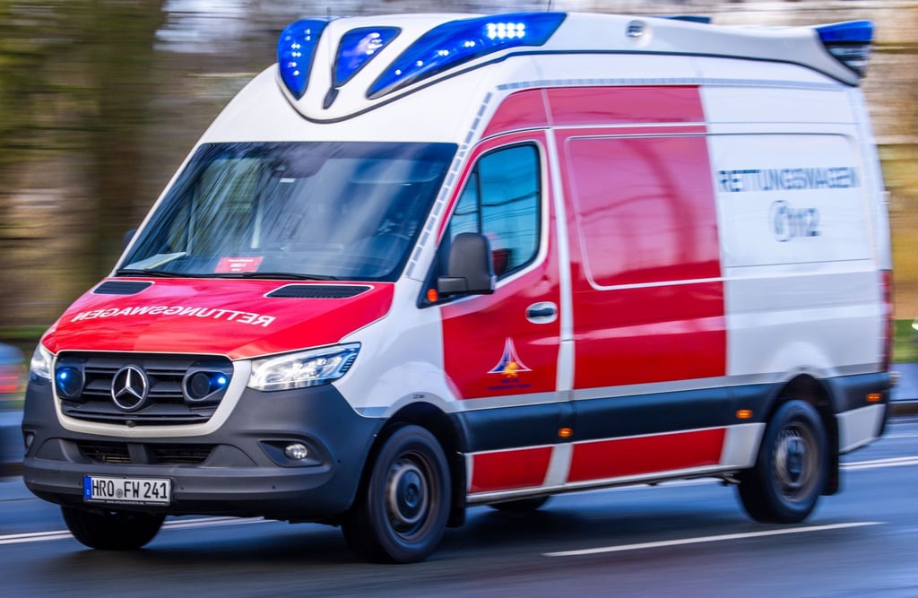 Ein Rettungsfahrzeug ist mit Blaulicht bei einem Noteinsatz in der Innenstadt unterwegs.
