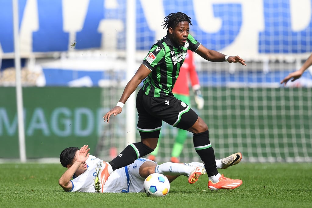 Hannovers Bright Arrey-Mbi (r) spielt gegen Magdeburgs Jason Ceka.