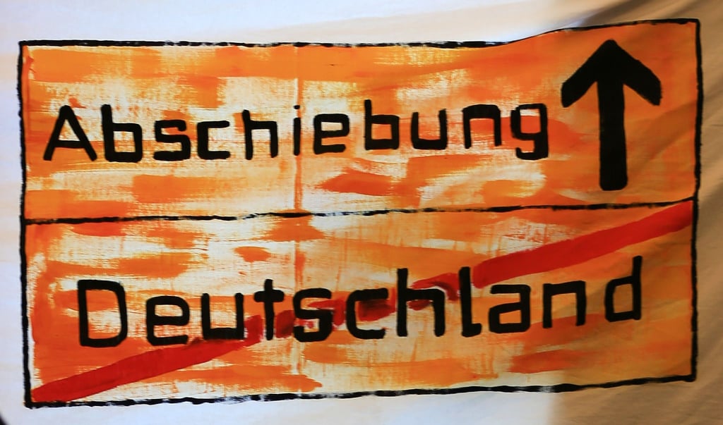 Ein Protest-Transparent hängt in einem Fenster.