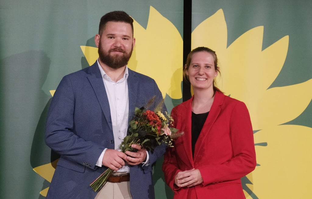 Dennis Hellmich und Madleine Linke, Vorsitzende von Bündnis 90 Die Grünen Sachsen-Anhalt, stehen auf einer Bühne.