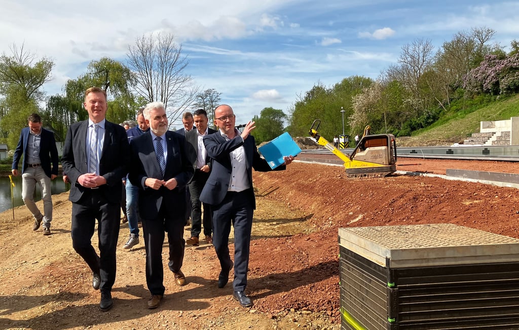 Stadtwerke-Geschäftsführer Eiko Fliege (r.) erklärt Wirtschaftsminister Armin Willingmann (M.) das Vorhaben im Klietz-Sportpark.