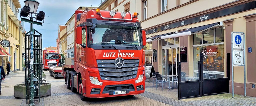 Zwei Lkw fahren am 12. April langsam durch die Breite Straße in Stendal.