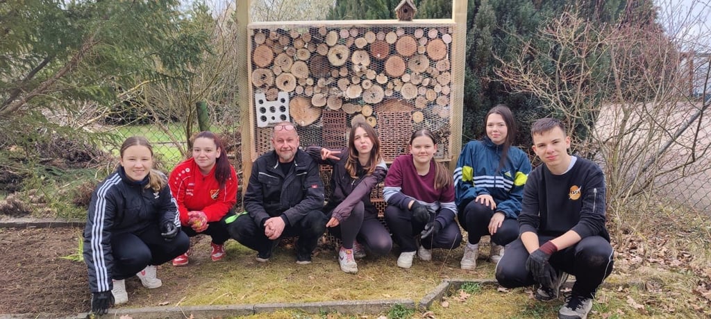 Die jungen Gärtner samt Bundesfreiwillige freuden sich über das große Insektenhotel, das sie gebaut und aufgestellt haben.