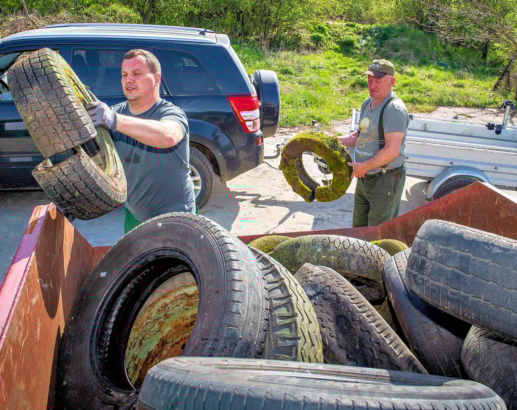 Der Hegering Löbitz macht im Wald bei Großwilsdorf klar Schiff – eine Arbeit, die man sich gerne sparen würde. Ralf Handrick und Gunter Baumgarten (r.) füllen einen Container mit Unmengen an Reifen.
